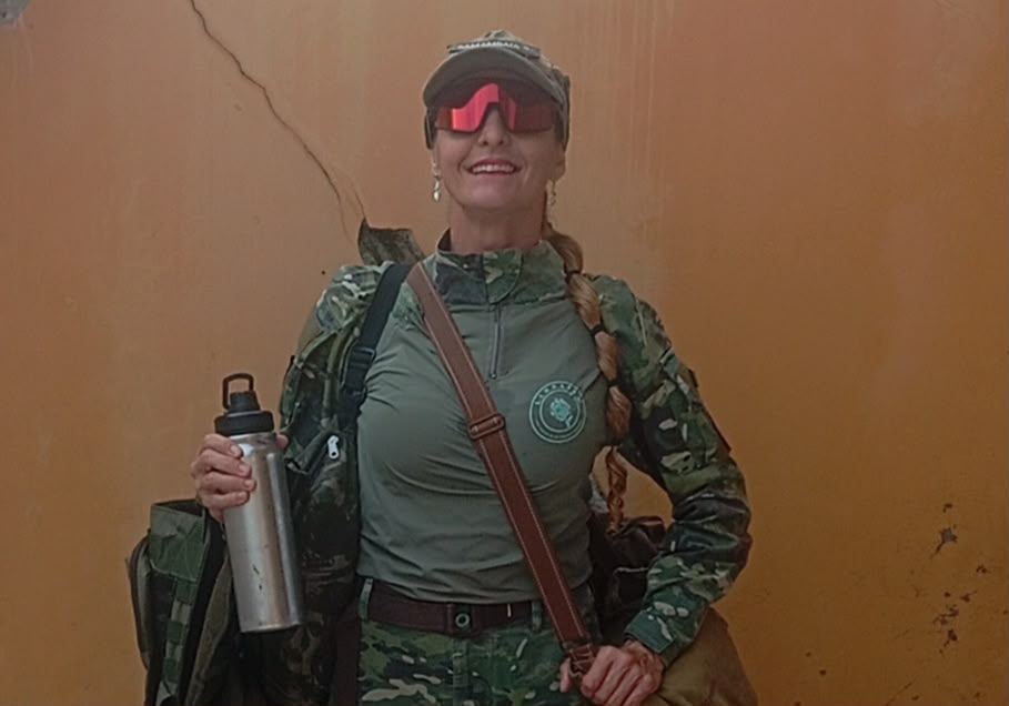 Integrante da LINDAFEM com uniforme de camuflagem em ambiente de mata